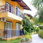 Descubra a vibrante fachada laranja dos apartamentos, que se harmoniza com a natureza exuberante do Thermas Park Resort.