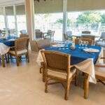 Restaurante com as mesas postas com detalhes das toalhas em azul